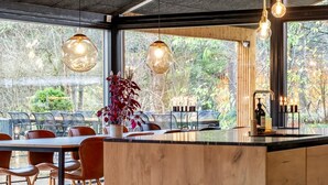 Una cocina moderna con una isla grande, armarios de madera e iluminación colgante.