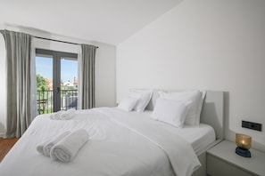 A hotel room with a large bed, white linens, a nightstand with a lamp, and a view of a balcony with curtains. - Villa Elaia With Heated Pool (Sukosan)