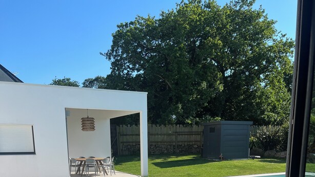 A modern outdoor patio with a swimming pool, outdoor furniture, and a stone wall. - Near La Baule/Historical center.  Villa located in a bubble of Serenity. (Guérande)