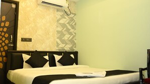 Un dormitorio moderno con una cama, ventilador de techo y aire acondicionado.