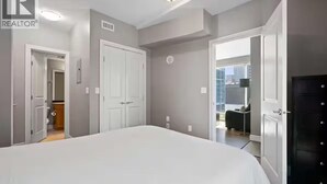 Quarto com uma cama grande, um guarda-roupa e uma porta que dá para uma varanda.