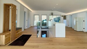 A spacious, modern kitchen with wooden flooring, a central island, and a view of the outdoors. - Modern loft for 6 with mountain views | Bad Ischl (Bad Ischl)