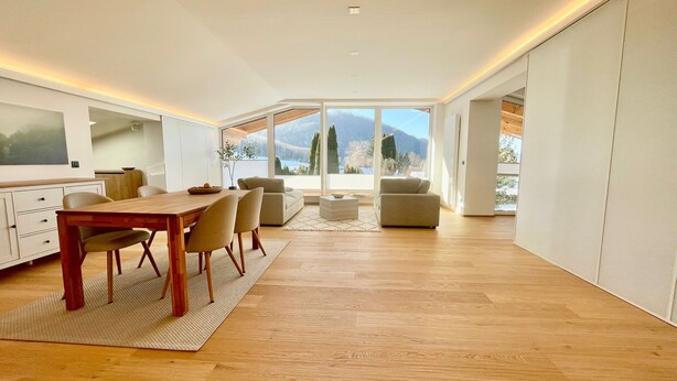A modern interior with a dining area, sofas, and a large window offering a mountain view. - Modern loft for 6 with mountain views | Bad Ischl (Bad Ischl)