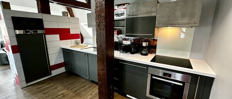 A modern kitchen with a built-in oven, a coffee machine, and a toaster.