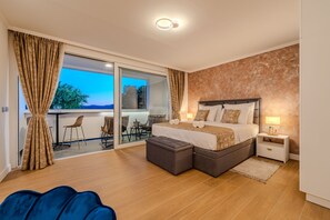 Een moderne slaapkamer met een groot bed, een nachtkastje, een stoel en uitzicht op de omgeving.
