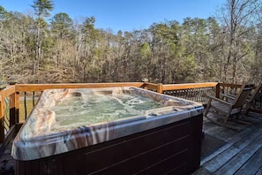 A hot tub on a wooden deck with a forest backdrop. - Private cozy log cabin-Your sweet spot in Smoky (Pigeon Forge)