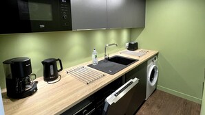 A compact kitchen with a microwave, coffee maker, sink, and washing machine. - L\"ecrin D\"edern Degle Mont Dore deg Ski Degrandonnee deg (Mont-Dore)
