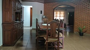 Comedor con pared de ladrillo, muebles de madera y piso de baldosas.