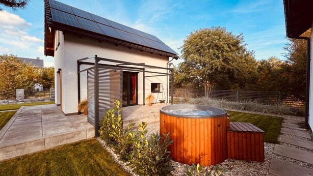 A modern house with a solar panel roof, a hot tub, and a patio area with a pergola. - Holiday Home, Sea, Jacuzzi, for 6 People (Wladyslawowo)