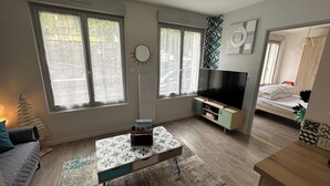 Ett modernt vardagsrum med en soffa, ett soffbord, en tv och en säng.