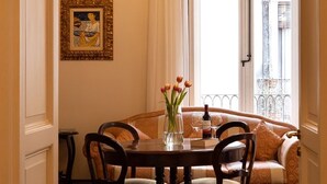 A dining area with a chandelier, a table with chairs, a vase with flowers, and a view of the outside. - Ferrari Mansion • Historic Noble Residence by the Cathedral (Catania)