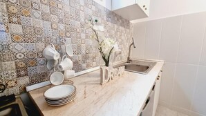 A kitchen with patterned tiles, a sink, and a decorative word 'DREAM' on the counter.
