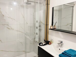 Chuveiro, secador de cabelo, toalhas de banho, sabonete