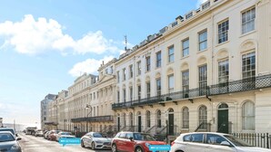 A row of classic European-style buildings with uniform architecture, featuring balconies and large windows. - Beach Reach | By My Getaways (Brighton)