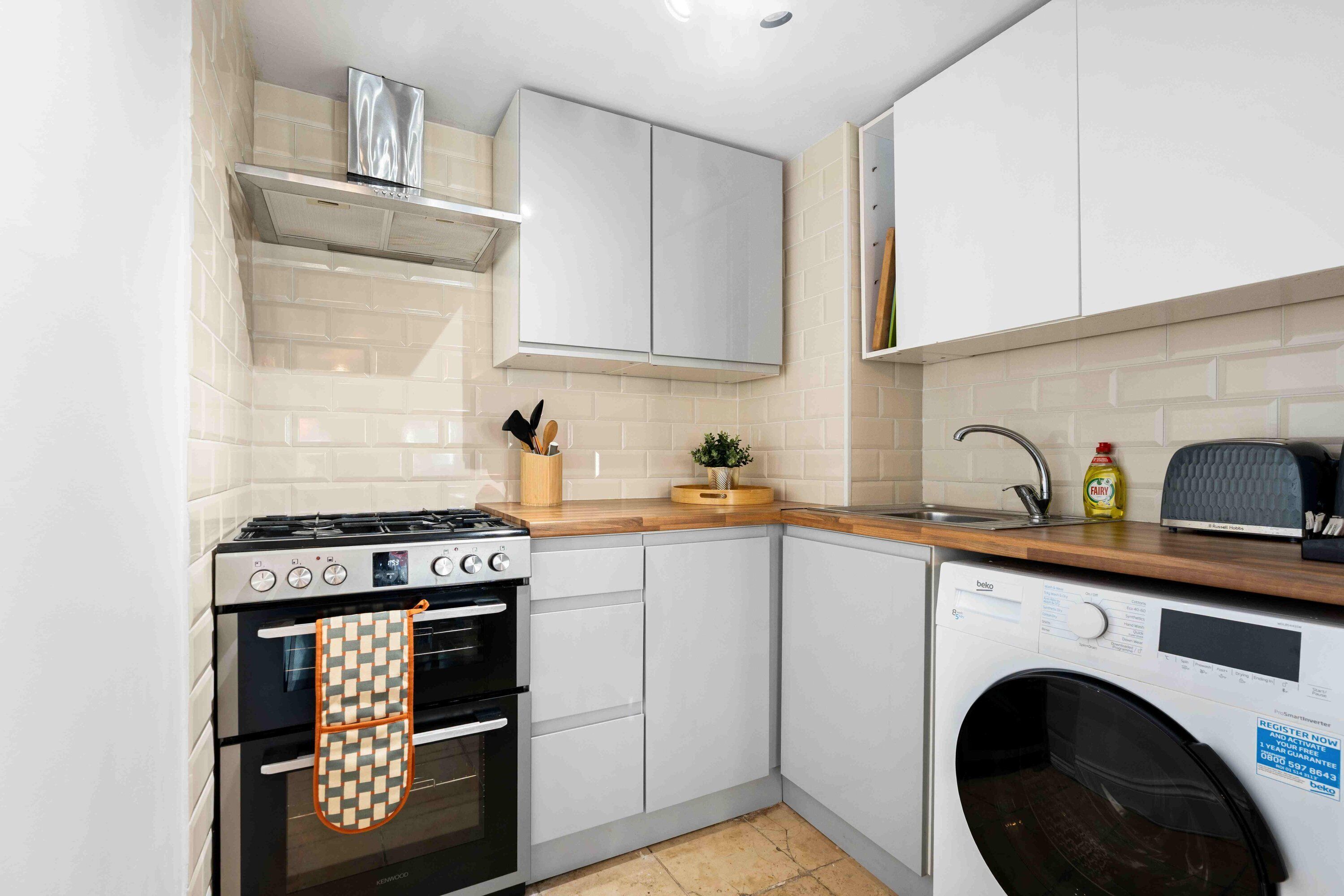 A compact kitchen with a stove, oven, dishwasher, and a sink.