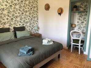 A bedroom with a bed, pillows, a chair, and a shelf with hats. - Large, spacious Germaine house in a quiet location 10 minutes from the sea. (Sibiril)