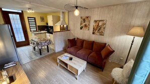 Una sala de estar con sofá, una mesa de centro y un comedor con sillas y mesa.