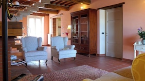 Una sala de estar con dos sillones, un aparador de madera y una puerta.