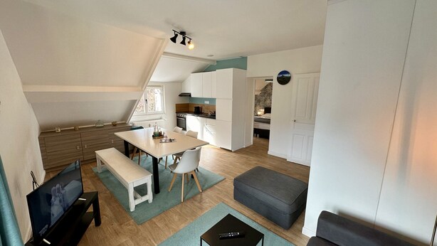 A compact living space with a kitchenette, a dining area, and a seating area. - Modern Family Villa in La Bourboule (La Bourboule)