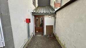 A narrow alleyway with a door, a red fire alarm box, and a metal gutter. - Modern Family Villa in La Bourboule (La Bourboule)