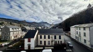 A town with buildings, a road, and mountains in the background. - Modern Family Villa in La Bourboule (La Bourboule)