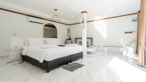 Une chambre d’hôtel moderne avec un grand lit, une petite table de chevet, un bureau et un miroir.