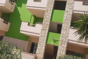 Ein mehrstöckiges Gebäude mit grüner Fassade und Steindetails.