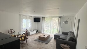 Una sala de estar moderna con un sofá, una mesa de centro y un televisor.