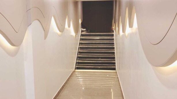 A modern staircase with a glossy floor and recessed lighting. - The Garrison Hotel (Meerut)