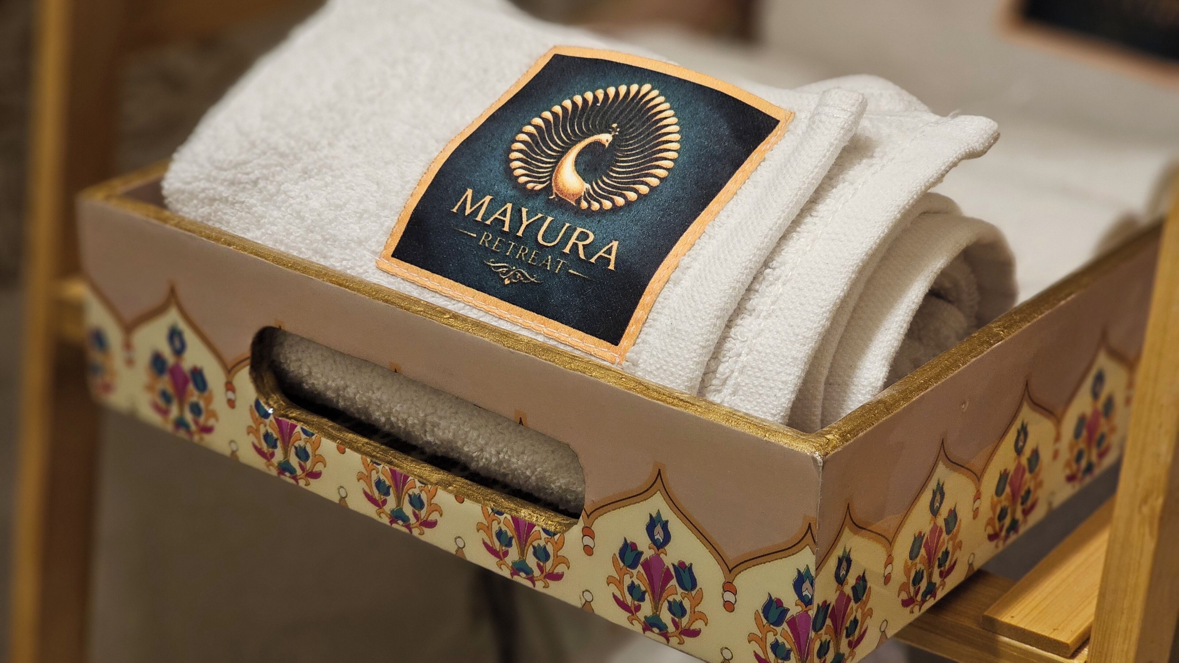 A box with a towel and a label that reads 'MAYURA RETREAT.'