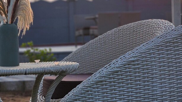 Wicker furniture, a vase with dried plants, and a sunset view. - Mayura Retreat (Danta Ramgarh)