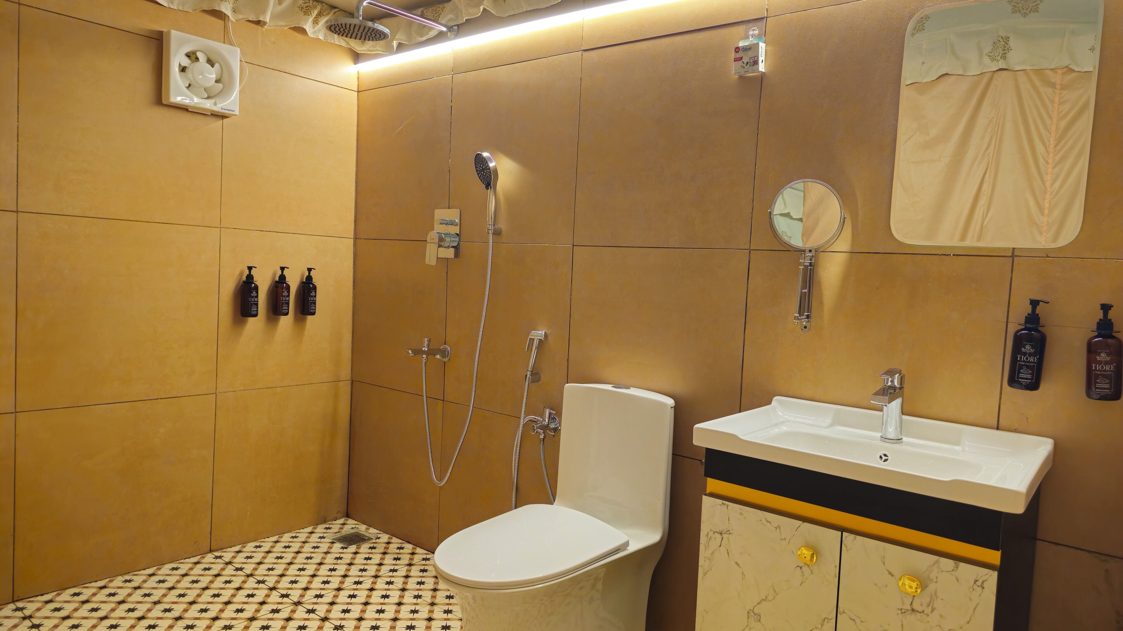 A bathroom with a toilet, sink, shower, and two bottles of toiletries.