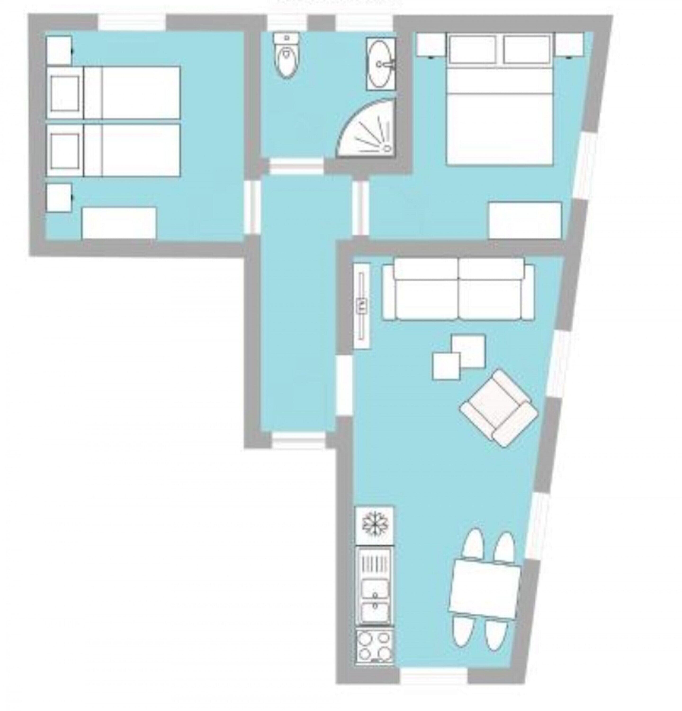 A floor plan of a hotel room with a bed, a desk, a chair, a small table, a sofa, and a bathroom with a toilet and sink.