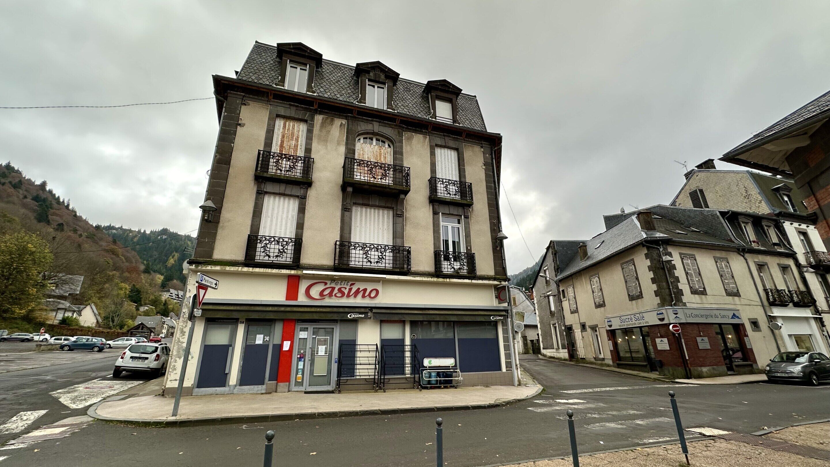 Un edificio con el rótulo 'Casino', que presenta una planta baja con puerta roja y ventanas con contraventanas.