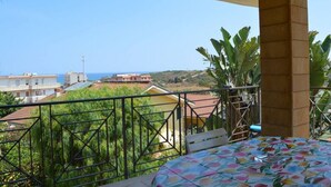 A balcony with a bed, a view of the sea, and surrounding buildings. - Holiday Properties Sicilian Breeze2 (Lido di Noto, Italy)