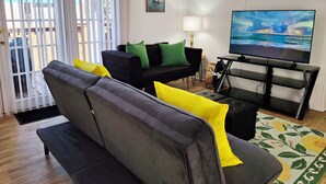 Una sala de estar con un sofá, un televisor y un cuadro en la pared.