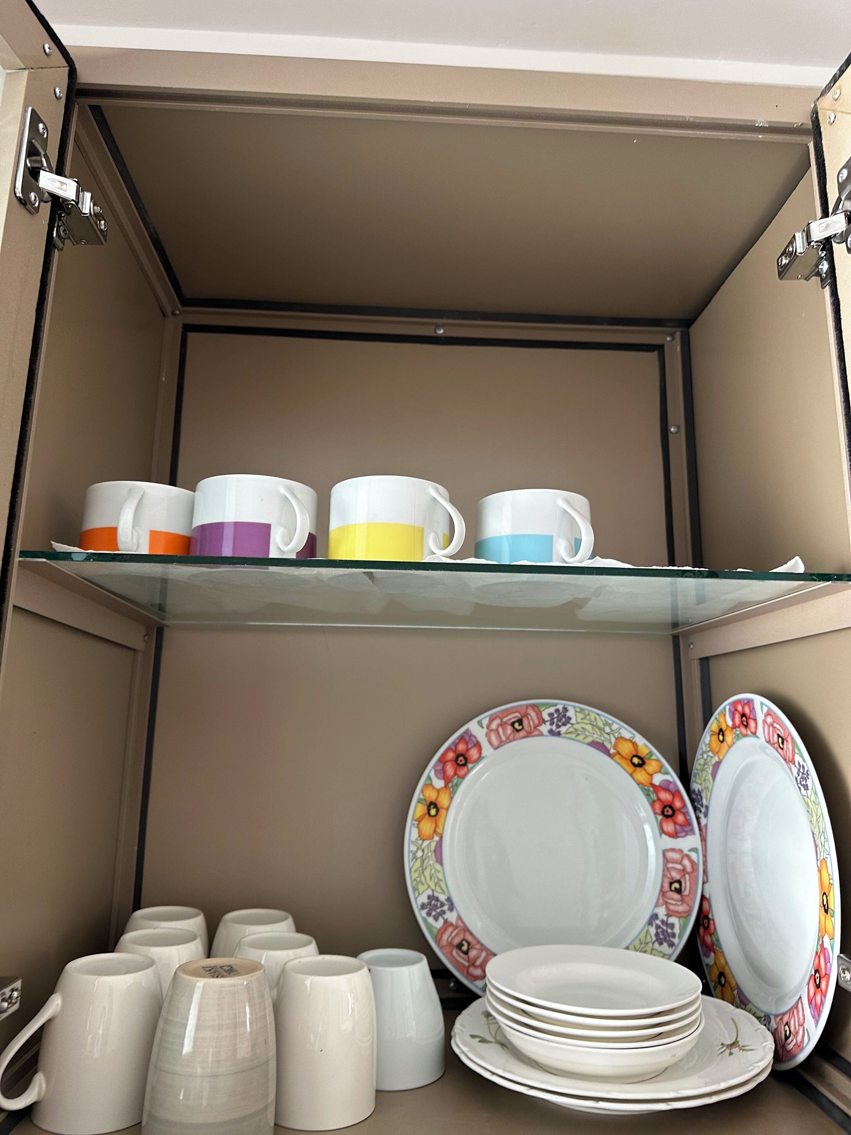 Un armario de almacenamiento con estantes que contienen varias tazas y platos.