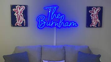 A neon sign reading "The Burnham" in a modern interior setting.