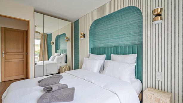 A hotel room with a large bed, a mirror, and a view of the outdoors. - PARIS - Adorable 3-room apartment with 2 bedrooms and 2 bathrooms (Bagnolet)