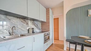 A modern kitchen with a marble backsplash, stainless steel appliances, and light-colored cabinetry. - PARIS - Adorable 3-room apartment with 2 bedrooms and 2 bathrooms (Bagnolet)