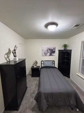 A bedroom with a bed, dresser, nightstand, and a painting on the wall. - Relaxing Stay in Friendly Home (Charlotte)