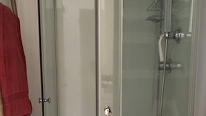 A glass-enclosed shower area with a white sink and a wooden ladder leaning against the wall. - Cozy French Alpine Retreat for 2 (Mont-Dore)