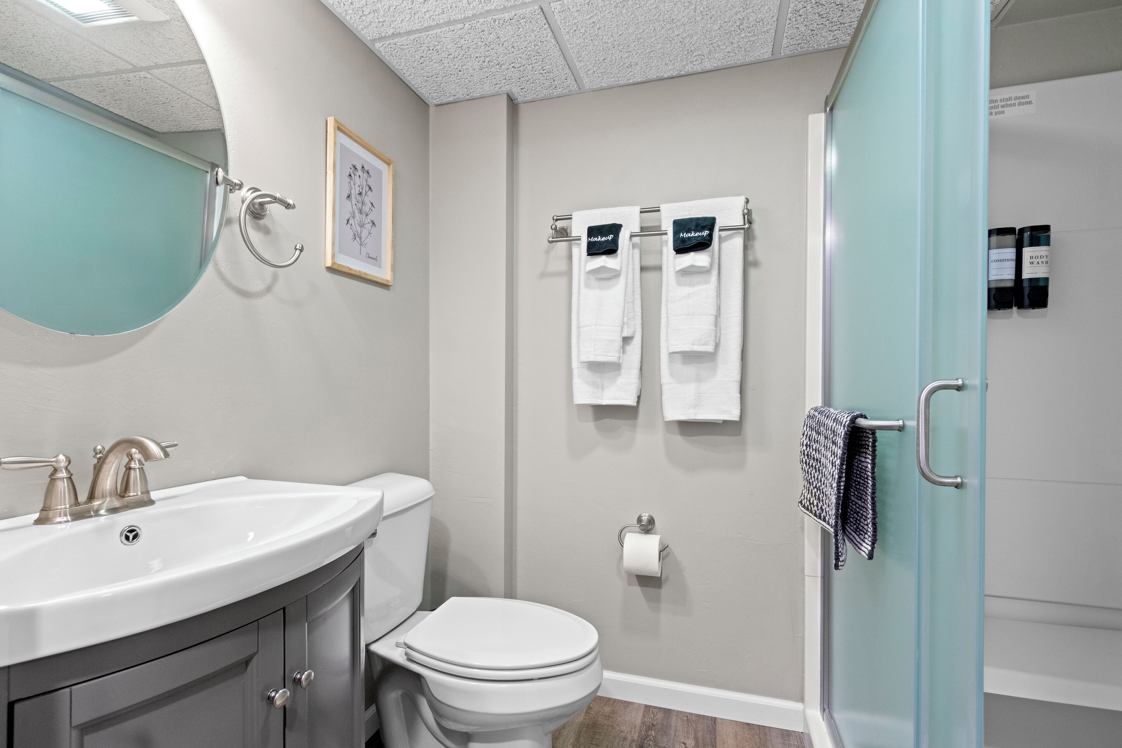 Une salle de bain comprenant un lavabo, des toilettes et un espace douche.