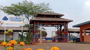 Uma entrada com portão e um pavilhão tradicional, placa com o nome