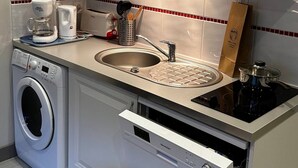 A compact kitchen with a microwave, coffee maker, sink, and a built-in dishwasher. - Charming Mont-dore Duplex Stay (Mont-Dore)