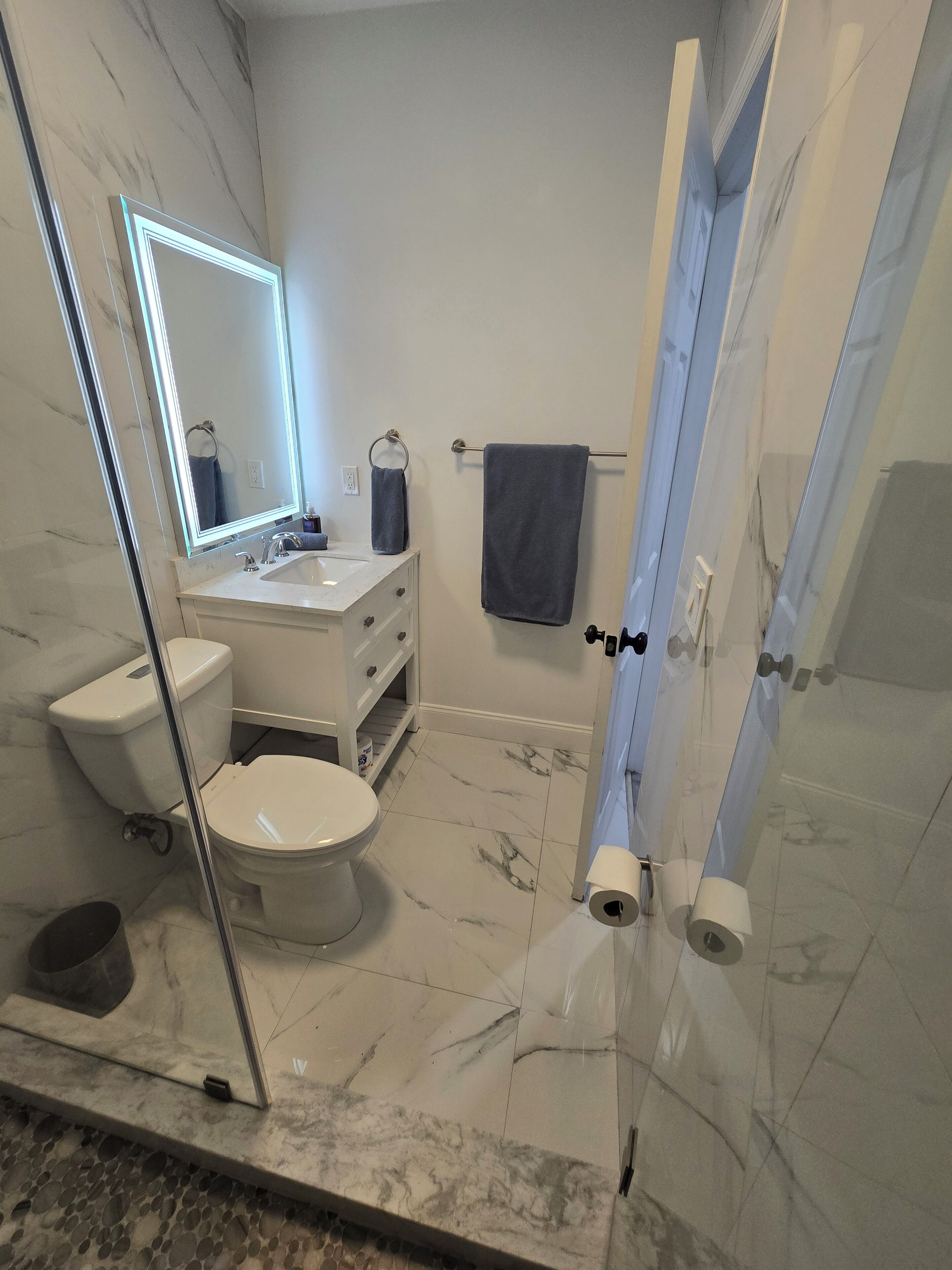 Une salle de bain comprenant des toilettes, un lavabo et un espace douche.