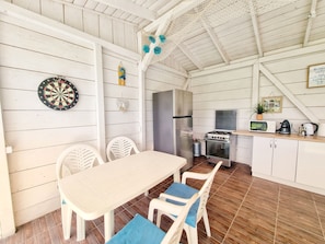 A kitchen with a dining table, chairs, a refrigerator, a stove, and a microwave.