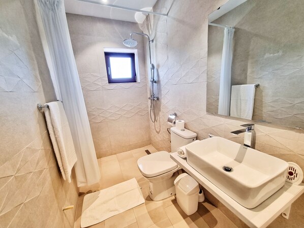 A modern bathroom with a bathtub, toilet, and sink.