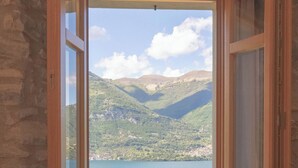 Una habitación con un ventanal grande que da a un lago y montañas.