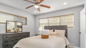 A bedroom with a bed, dresser, mirror, and ceiling fan. - Home in Dallas / Entire Home (Dallas)